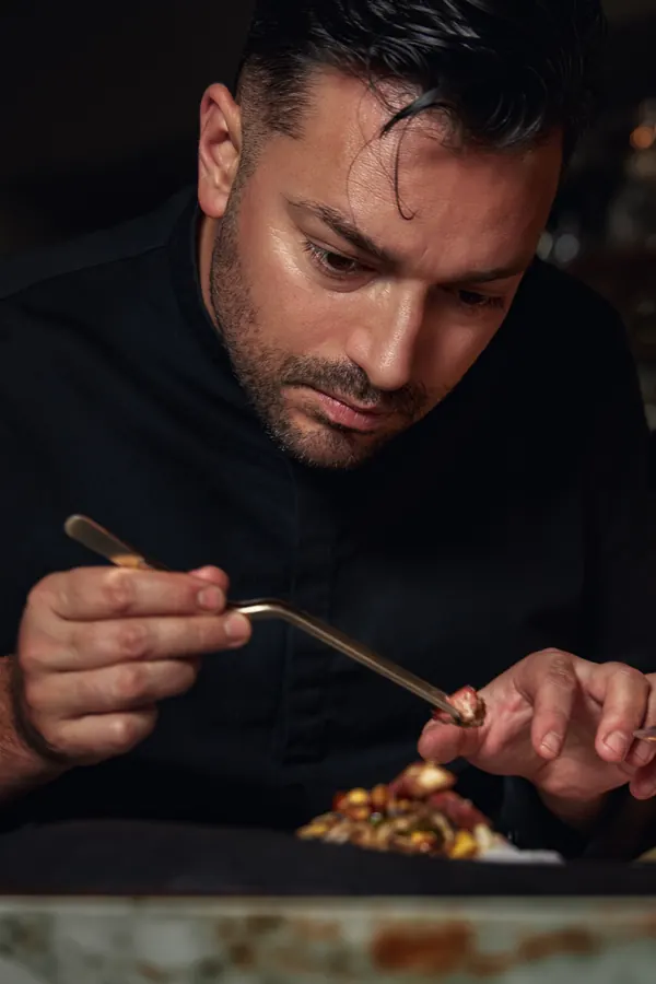 Chef termina un plato con pinzas