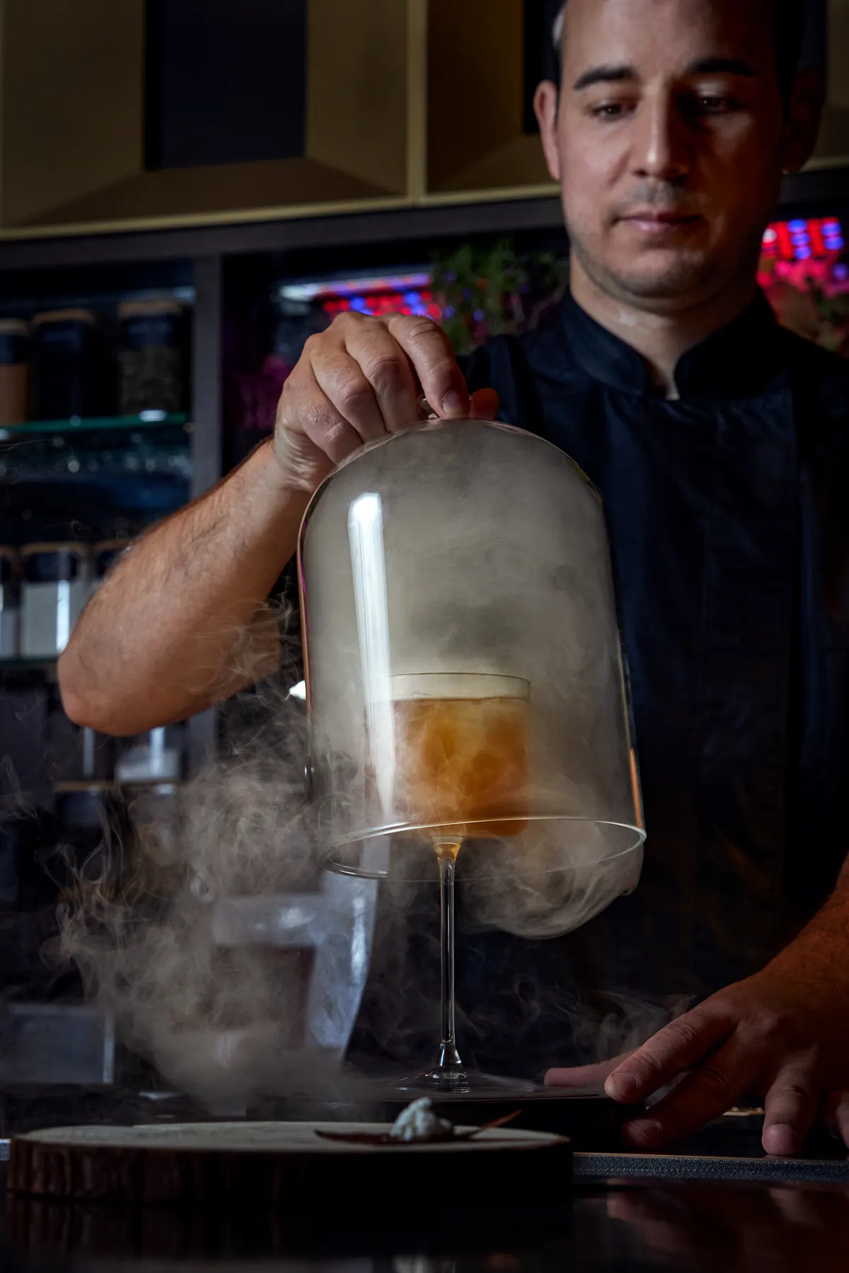 Bartender levanta una campana de humo sobre un cóctel