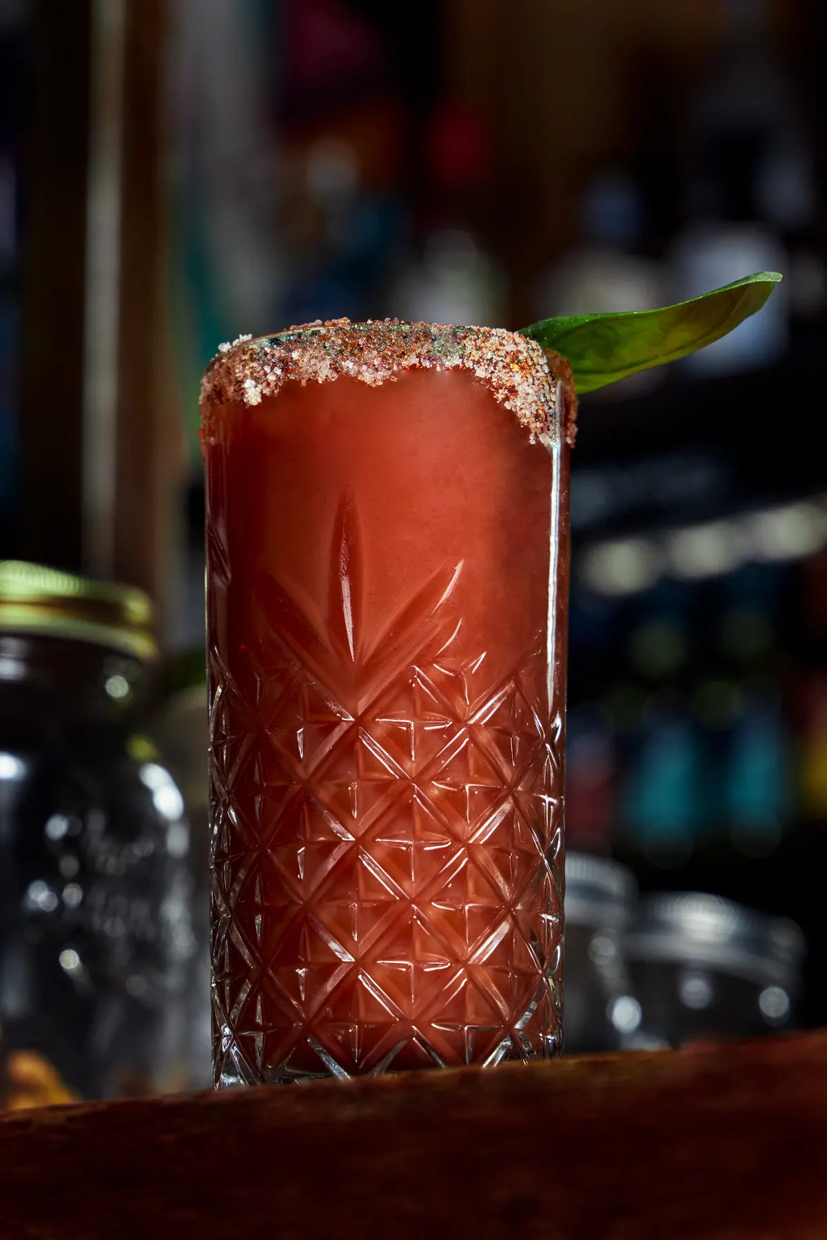 Cóctel rojo con borde de sal en vaso tallado
