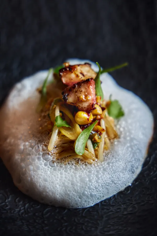 Plato con espuma, verdes y pescado marcado